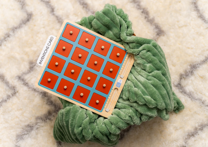 Close-up of child lifting a wooden tile from the Lil Crescent Muslim Memory Game board — Islamic matching game with orange wooden tiles, ages 3 plus